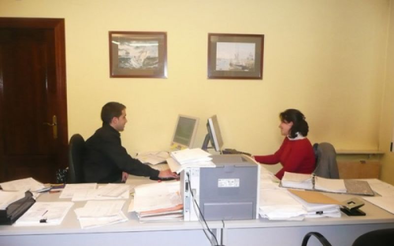 Dos trabajadores trabajando en mesas uno frente al otro