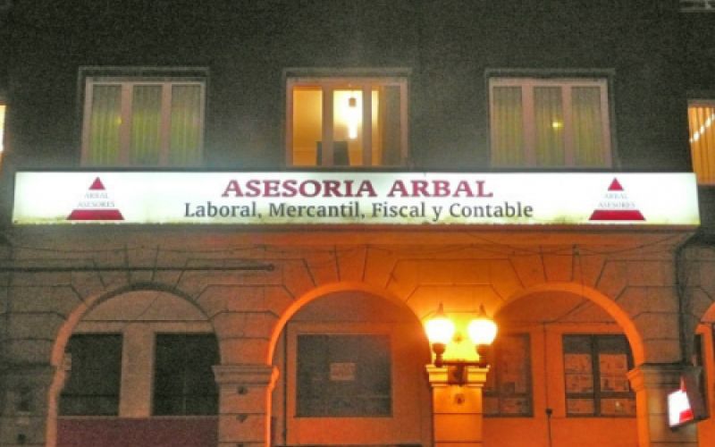 Fachada con letrero de asesoría de noche